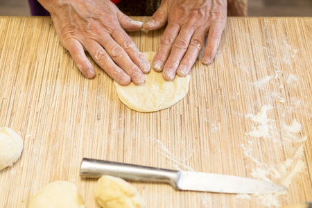Female hands preparing dough pies to bakeの写真素材