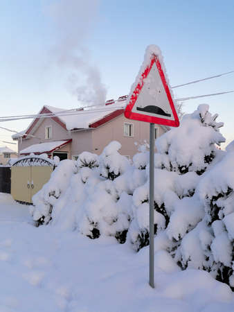 Road sign in suburbs and smoke from chimney of cottage in frosty winterのeditorial素材