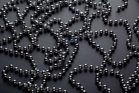Bright sparkling silver beads in chaotic lines on black background