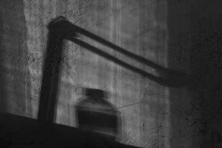 Background of harsh shadows on grungy textured wall of setting sunの写真素材