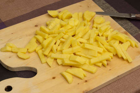 Chopped potatoes for soup on a wooden cutting board