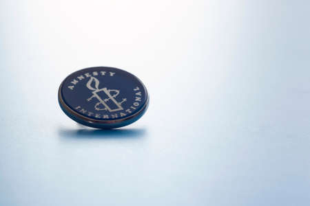 Human rights organization Amnesty International badge with a burning candleのeditorial素材