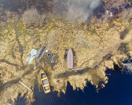 Old fishing boats on the flooded lake shore in spring, aerial view