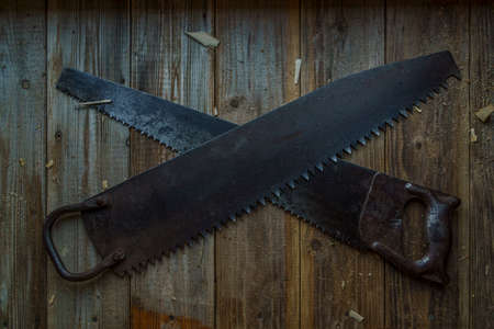 Vintage one-handed saw and handsaw on wooden crafting table of workshopの写真素材