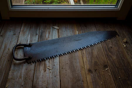Vintage one-handed sharp saw on wooden crafting table of workshop