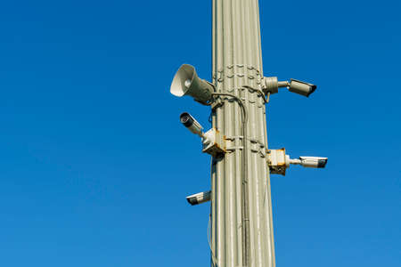 CCTV security cameras and outdoor loudspeaker on clear blue sky backgroundの写真素材