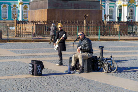 Street musicians playing rock on guitars in St. Petersburg on Palace Square