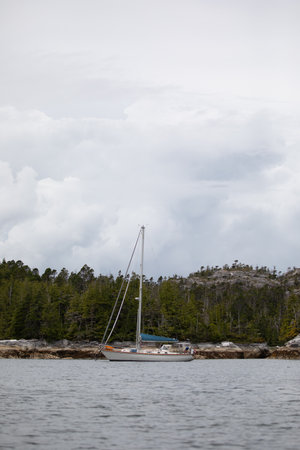 A beautiful sailboat in a remote anchorage with mountains in the backgroundの写真素材