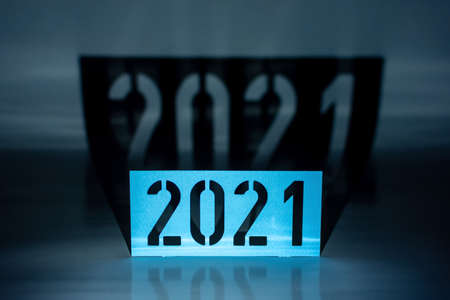 The year 2021 as a graphic element, blue with ominous black shadows as a paper cutの写真素材