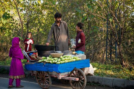 Islamabad, Islamabad Capital Territory, Pakistan - February 2, 2020,  Young boys are roasting fresh corn for the customers.のeditorial素材