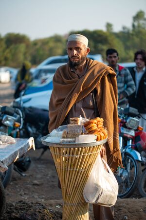 Islamabad, Islamabad Capital Territory, Pakistan - February 05, 2020, An old man selling home mades traditional sweets on the street in Islamabad,のeditorial素材