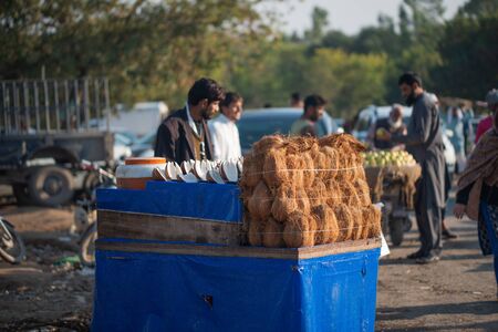 Islamabad, Islamabad Capital Territory, Pakistan - February 03, 2020, A man is selling peeled coconuts & coconut water on the street.のeditorial素材