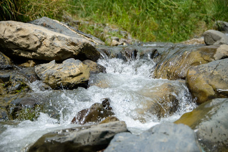 Water flowing over river rocks near mountains in Nathia Gali, Abbottabad, Pakistan.