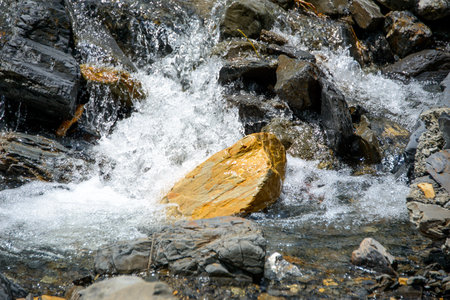 Water flowing over river rocks near mountains in Nathia Gali, Abbottabad, Pakistan.