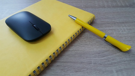 Agenda with pen and mouse on wood deskの素材