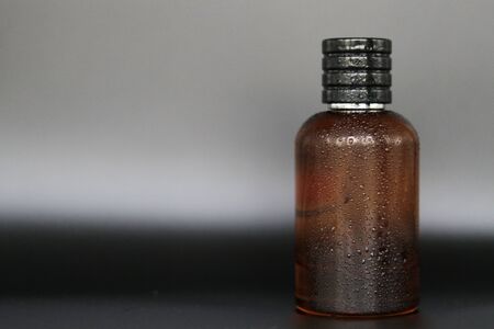 Red color glass perfume bottle without label or sticker in a black backgroundの写真素材