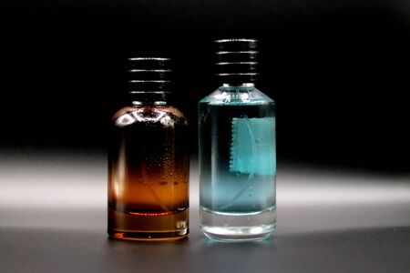 Red color glass perfume bottle without label or sticker in a black backgroundの写真素材