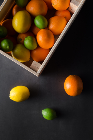 Limes, lemons and oranges in a wooden crate.の写真素材