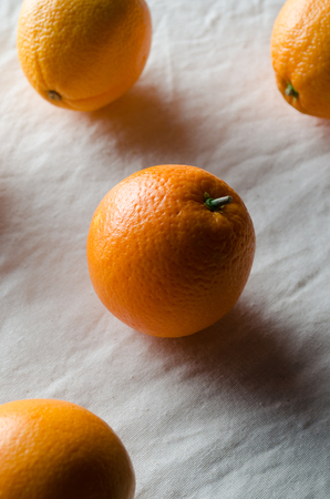 Oranges on a white linen tablecloth.の写真素材