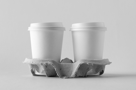Two 12 oz. white coffee paper cups with lid in a holder. Blank Mock-Up.の写真素材