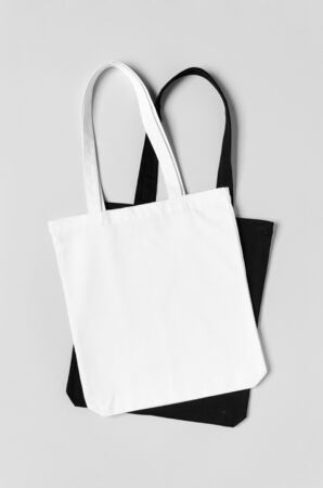 White and black tote bags mockup on a grey background.の写真素材