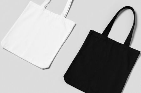 White and black tote bags mockup on a grey background.の写真素材
