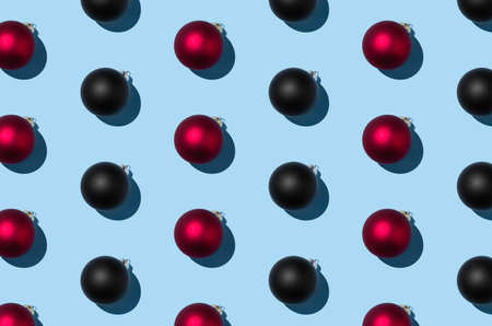 Red and black Christmas balls pattern on a pastel blue background.