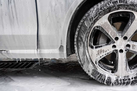 Car washing concept. Car in foam, closeup.の写真素材