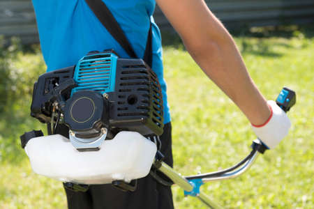 The man cutting a grass with the lawn mower. Closeup.の写真素材