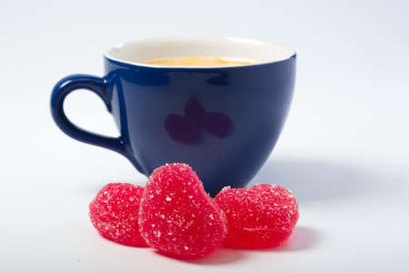 Marmalade candies at the background of a cup with coffee.の写真素材