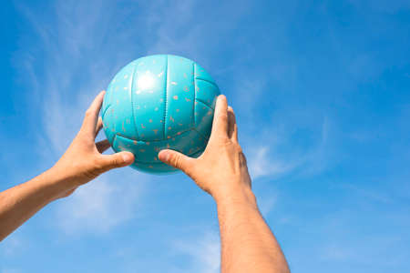 Woman hold volleyball in her hands. Blue background.の写真素材