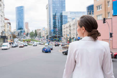 A young woman at the city street background, a back view.の写真素材
