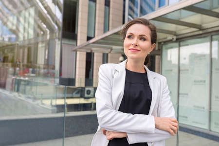 A portrait of a confident woman in the street near the office. A company employee.の写真素材