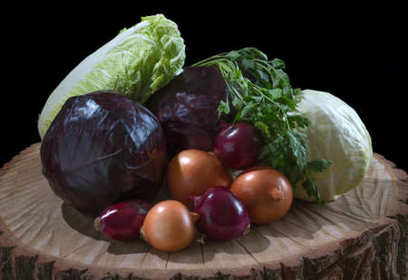 Organic vegetables on the wooden table and black background.