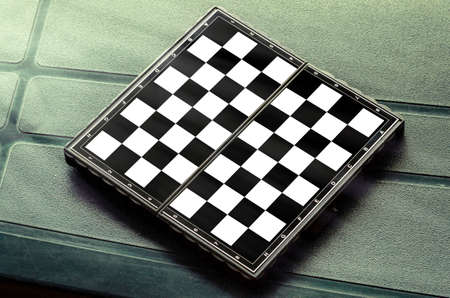 Empty chess board on green on the table.