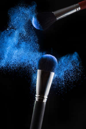 Professional brushes and blue powder on a black background. Make-up, Cosmetics.の写真素材