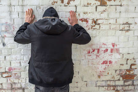 Addict on a brick wall background. Man experiencing a drug addiction crisis. Addiction concept.の写真素材