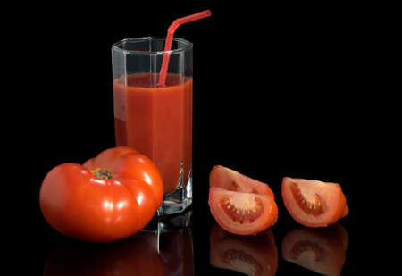 Juicy fresh red tomatoes. Tomato segments on a black backgroundの写真素材