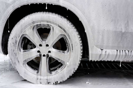 Car in foam. Car washing concept. Autowashing. Cleaning of the car on car washの写真素材