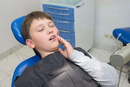 A boy with a swollen jaw after a professional pulling out a tooth.の写真素材