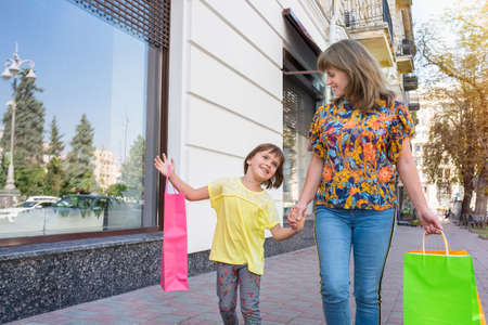 A happy girl shares the impressions with a mother, after purchases in a shop.の写真素材