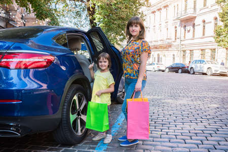 Mother and child on a street with shopping bags.の写真素材