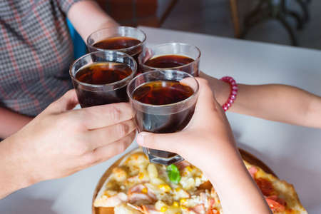 Group of hands with cola close up. The concept of celebration and friendship.の写真素材