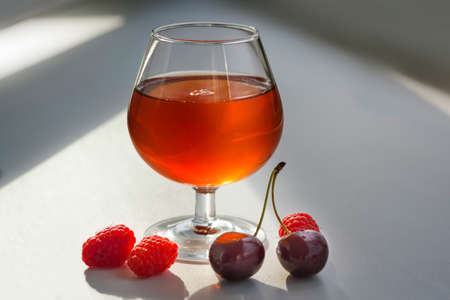 Fresh raspberries and cherries with a glass of wine.の写真素材