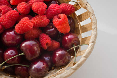 Fresh berries close-up in a wicker bucket.の写真素材