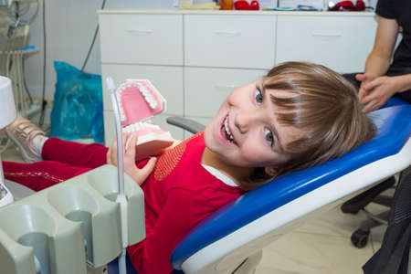 A happy girl with a jaw mock in a dentists office.