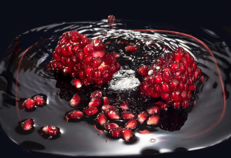Juicy seeds of pomegranate in own juice. Close up against a dark background.の写真素材