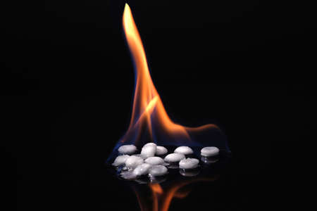 Drug disposal. White pills on fire on a black background. Stop to drugs.