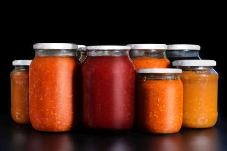 Pickled vegetables on a black background. Preservation in glass jars. Ingredients for canning vegetables.の写真素材