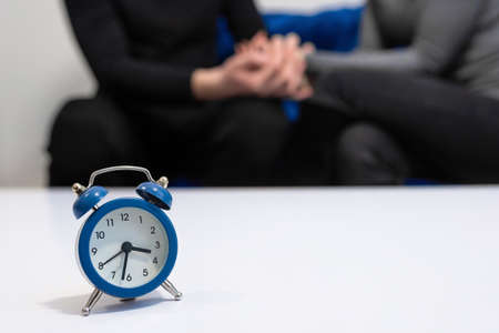 Doctors consultation with patients in the hospital office. Clock on the table in the office of a...